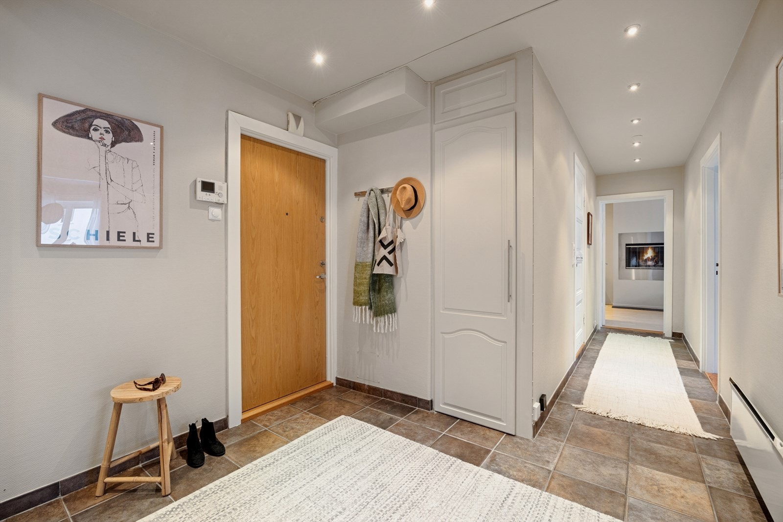 Entreen er flislagt med god plass til oppheng av ytterklær og sko. Bak døren på bildet er det også etablert et smart lite kott med praktisk utslagskum. Galleribilde