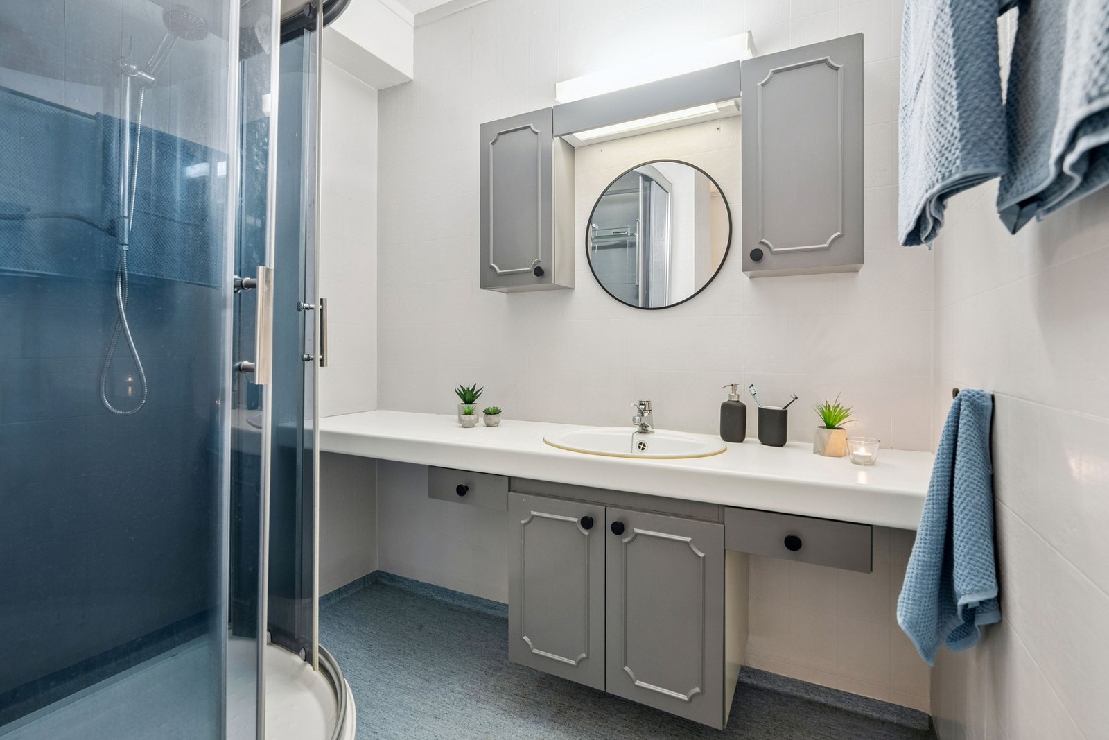 Badet er innredet med baderomsinnredning med heldekkende servant, speil med belysning og overskap. Galleribilde