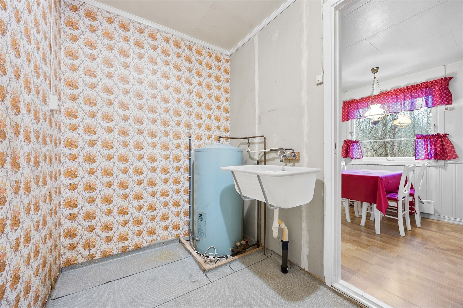 Opprinnelig bod benyttet som vaskerom og våtrom med varmtvannsbereder og utslagsvask. Belegg på gulv og tapetserte overflater. Galleribilde