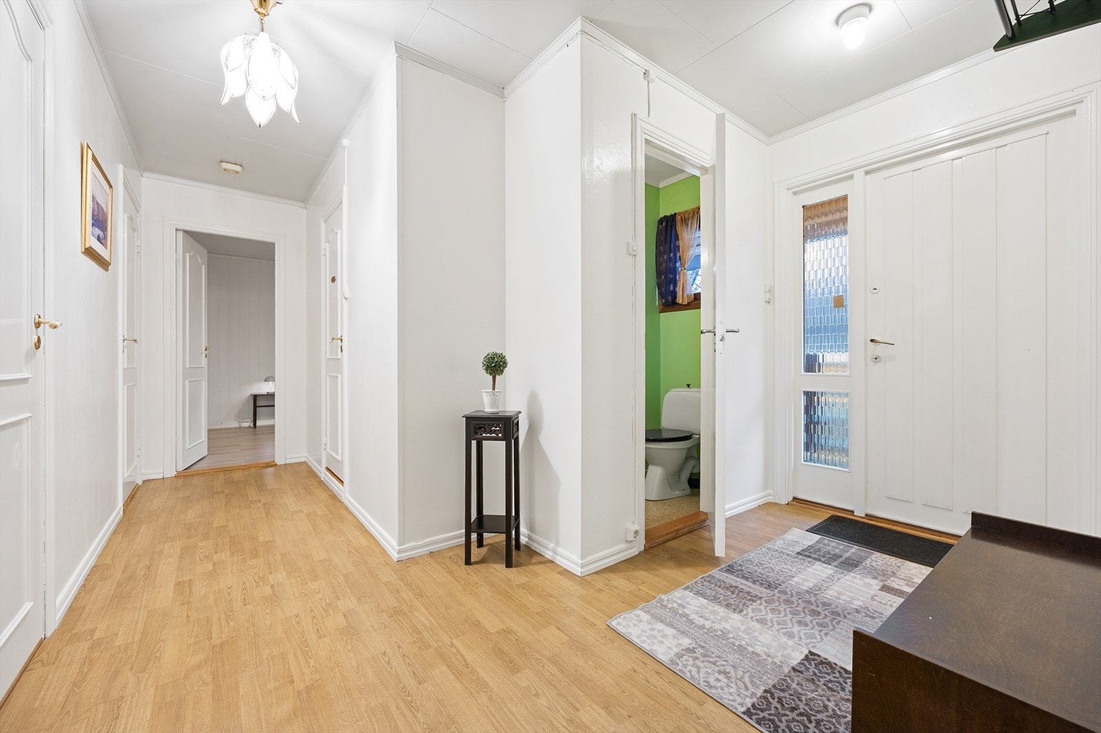 Lys entré med mulighet for oppheng av yttertøy og plassering av sko. Laminat på gulv og malte overflater. Galleribilde