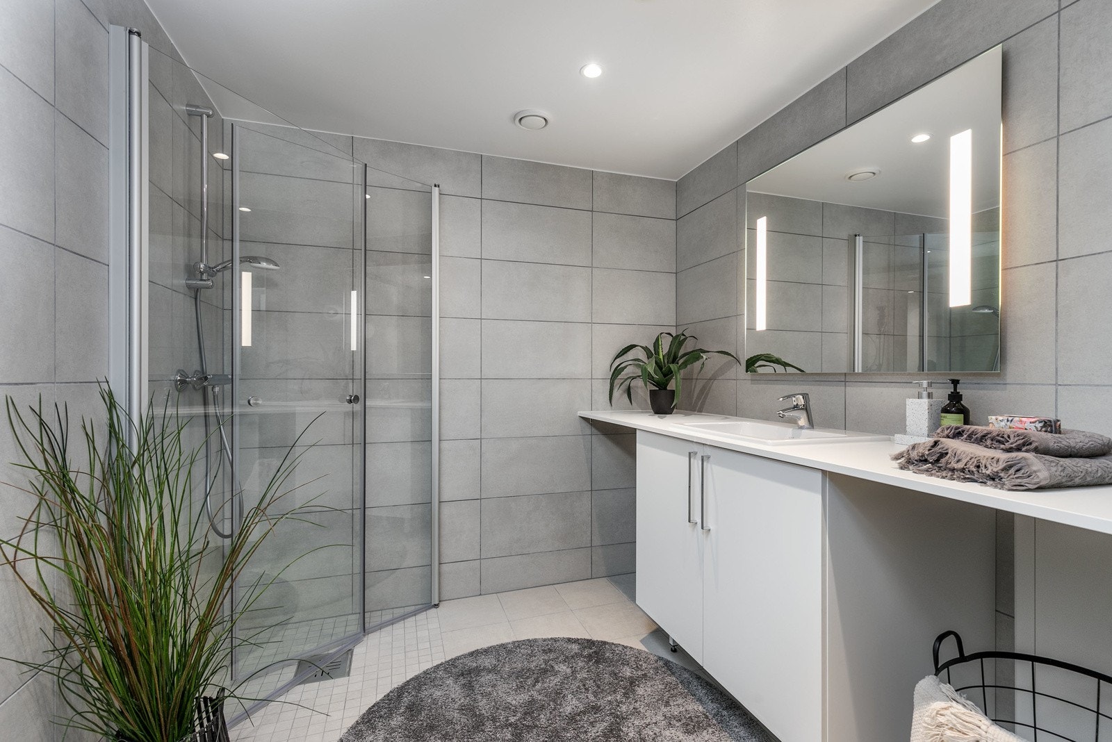 Badet har vegghengt toalett med innbygget sisterne, servant med skapinnredning samt speil med belysning. Galleribilde