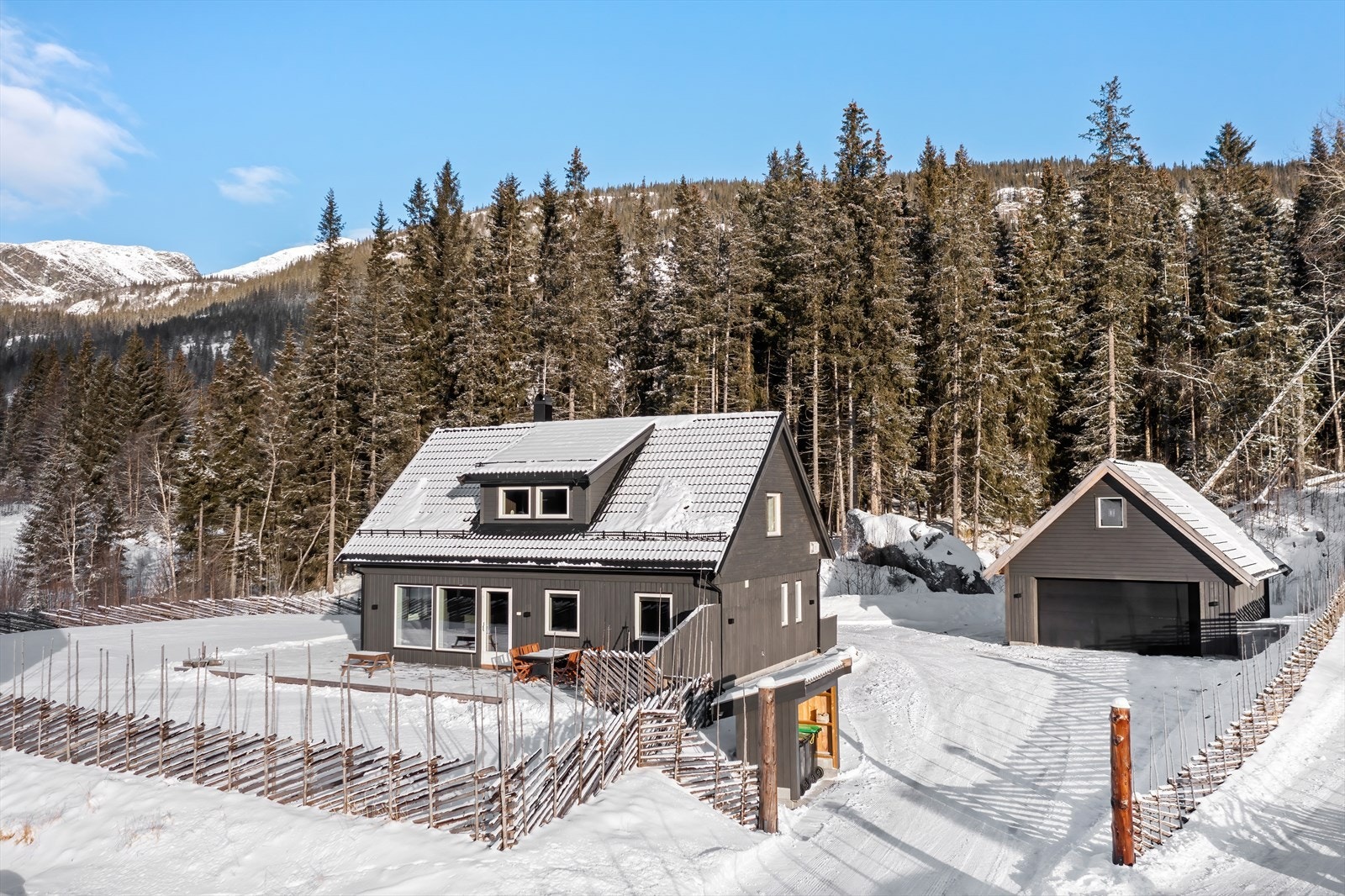 Tomten er inngjerdet med skigaard og portstolper ved innkjøringen. Galleribilde