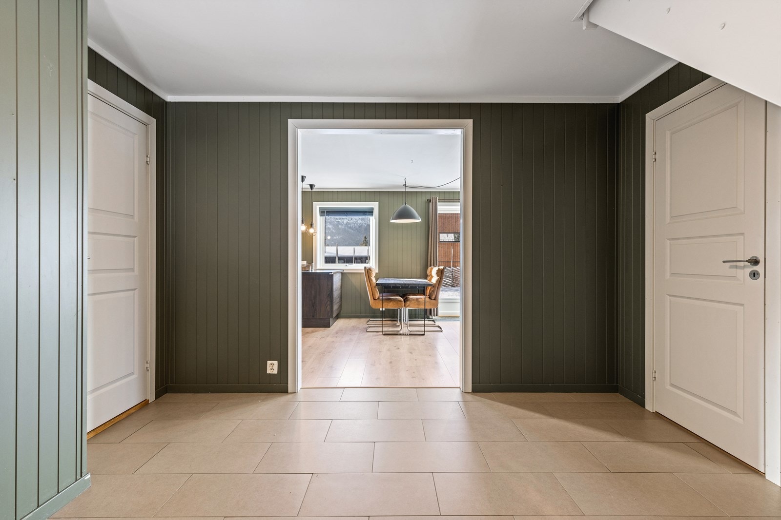 Romslig flislagt hall med inngang til vaskerom, baderom og soverom. Galleribilde