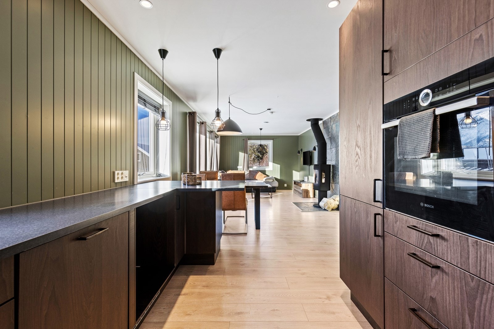 Spisebordet plassert mellom kjøkken og stue med fjellutsikt. Galleribilde