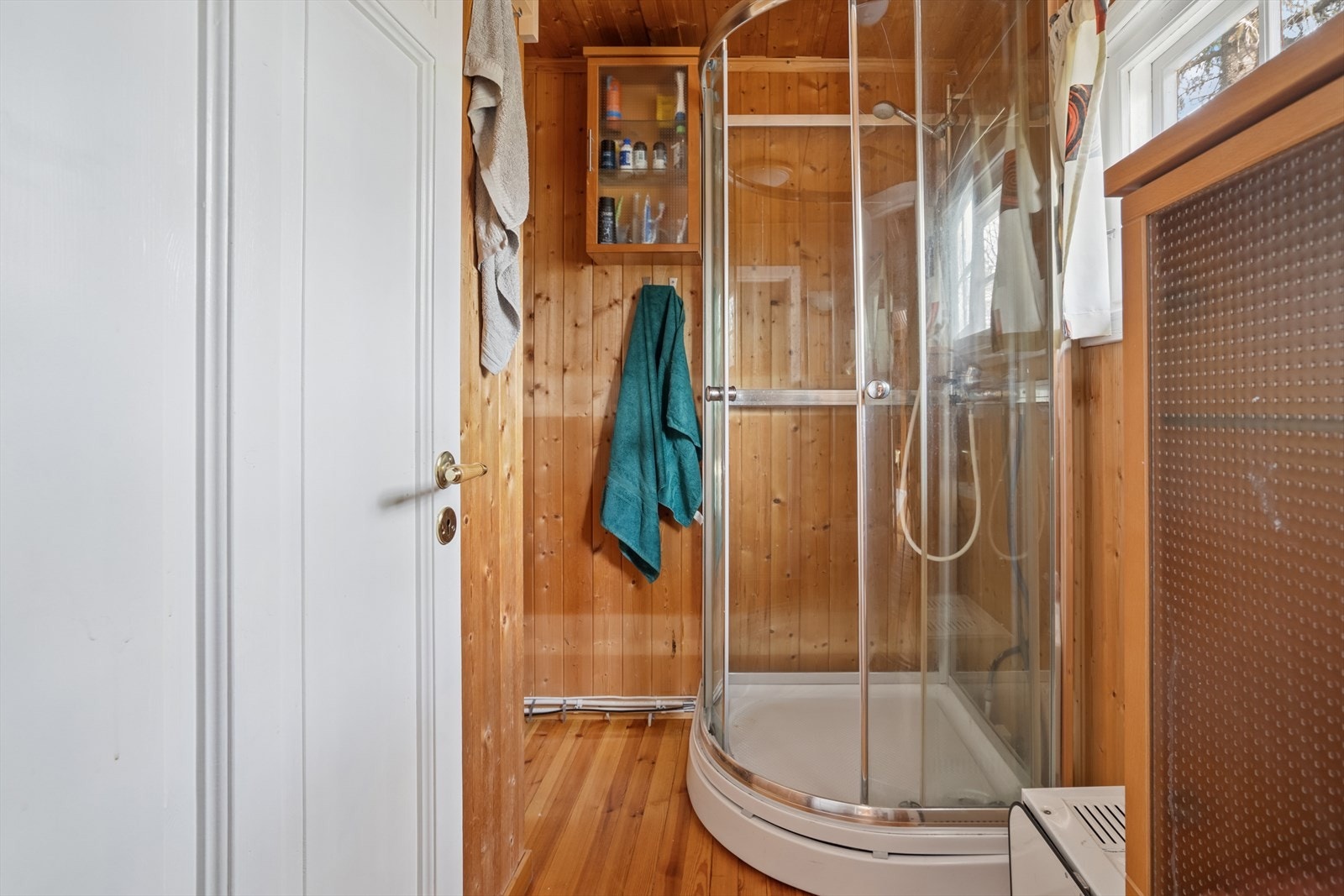 Bad - Veggene har panel. Gulvet er av tre. Rommet har innredning med nedfelt servant og dusjkabinett. Naturlig ventilering. Galleribilde