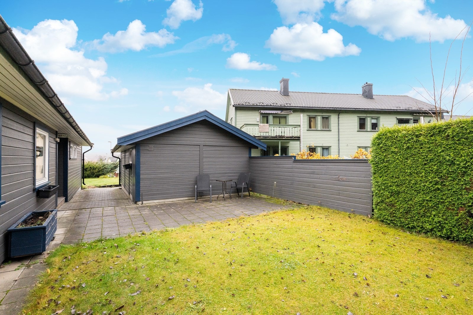 I bakkant av garasjen mot sydvest er det etablert en lun og koselig uteplass med tilliggende hageflekk. Galleribilde