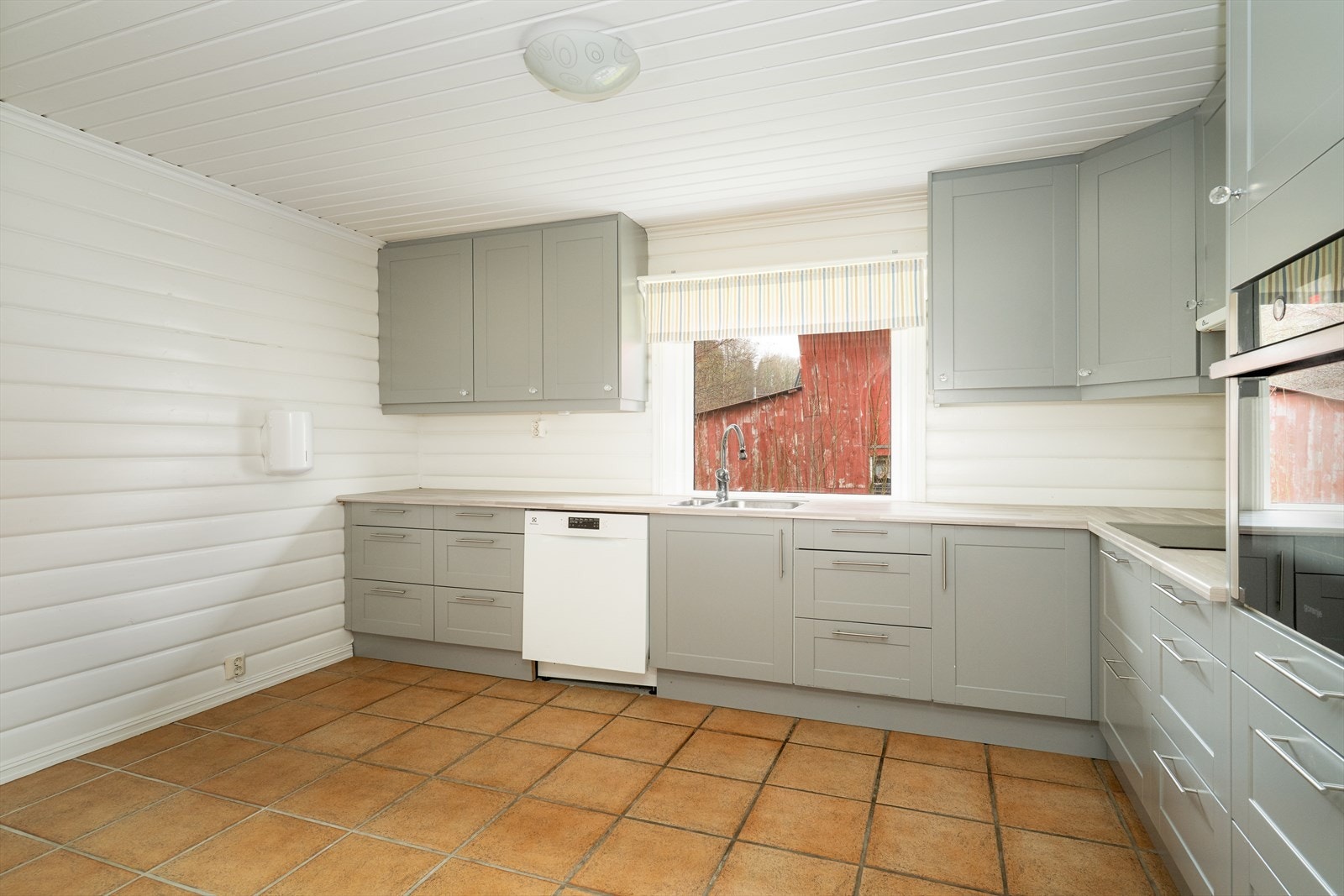 Også her er det flislagt gulv med varmekabler. Kjøkkenet har integrert koketopp og stekeovn, samt at det er avsatt plass til frittstående oppvaskmaskin og kjøleskap. Over koketoppen er det ventilator med avtrekk ut i yttervegg. Galleribilde