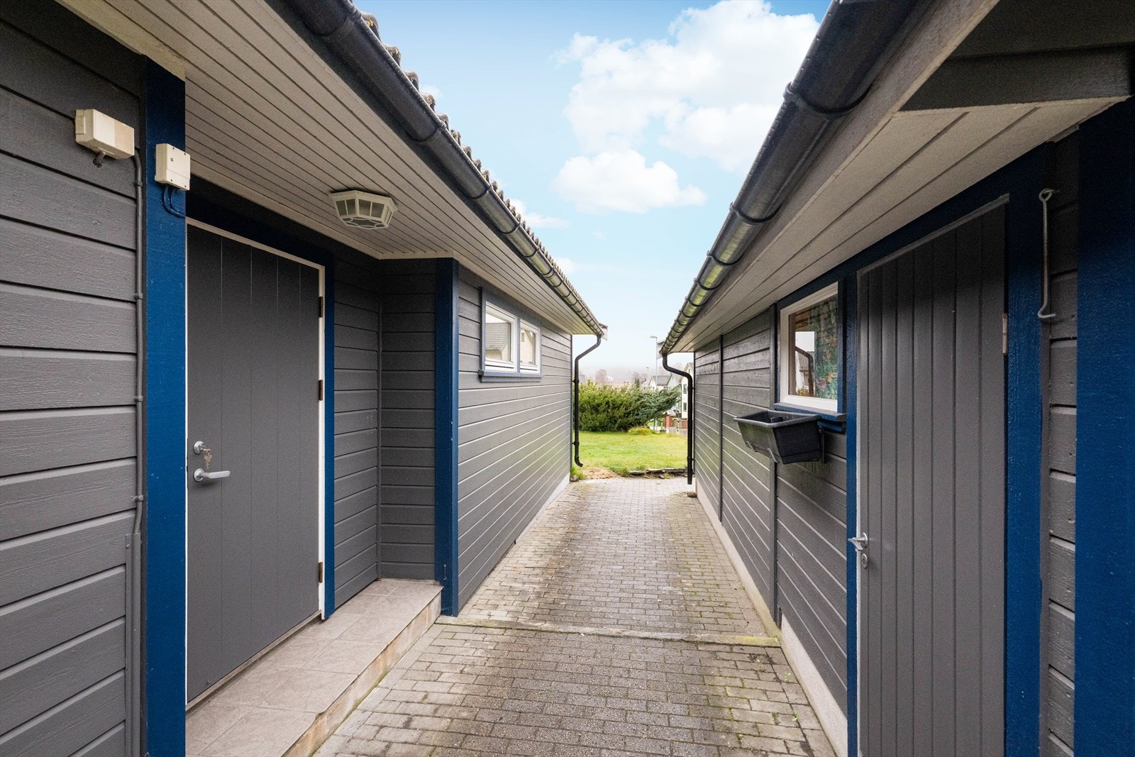 Belegningssteinen er videreført mellom garasjen og huset, inn mot inngangspartiet og den lune uteplassen. Galleribilde