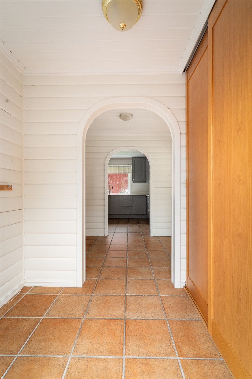 Når du trer inn i den innbydende entreen, blir du møtt av et flislagt gulv og malte panelvegger som er videreført inn i boligen og gir en fin helhet. Galleribilde