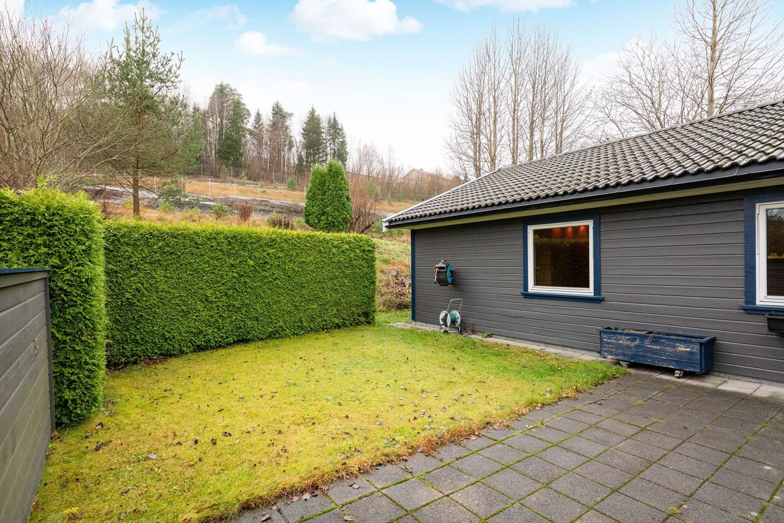 Denne uteplassen er fint skjermet med levegg og tujahekk mot naboeiendommen. Galleribilde