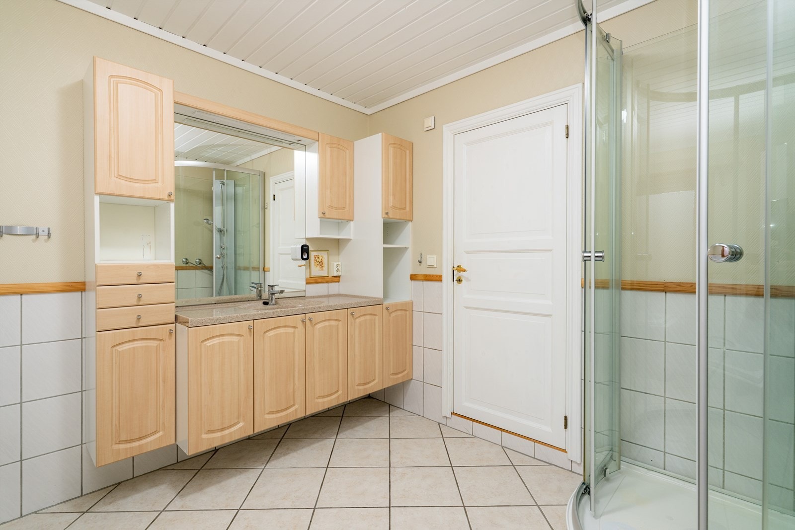 Badet, som opprinnelig er fra byggeår, ble oppgradert i 2000 med nye fliser, varmekabler og baderomsinnredning. Den romslige innredningen har godt med oppbevaringsplass, samt heldekkende servant og stort speil. Galleribilde