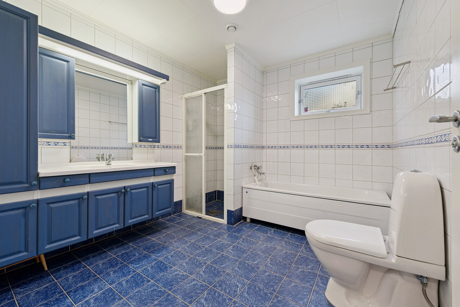 Romslig, flislagt bad i underetasjen, utstyrt med både dusjnisje og badekar. Galleribilde