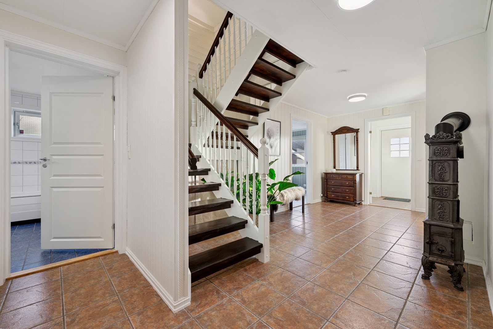 Fra hallen fører trappen opp til hovedetasjen. En eldre vedovn gir ekstra varme og særpreg. Galleribilde