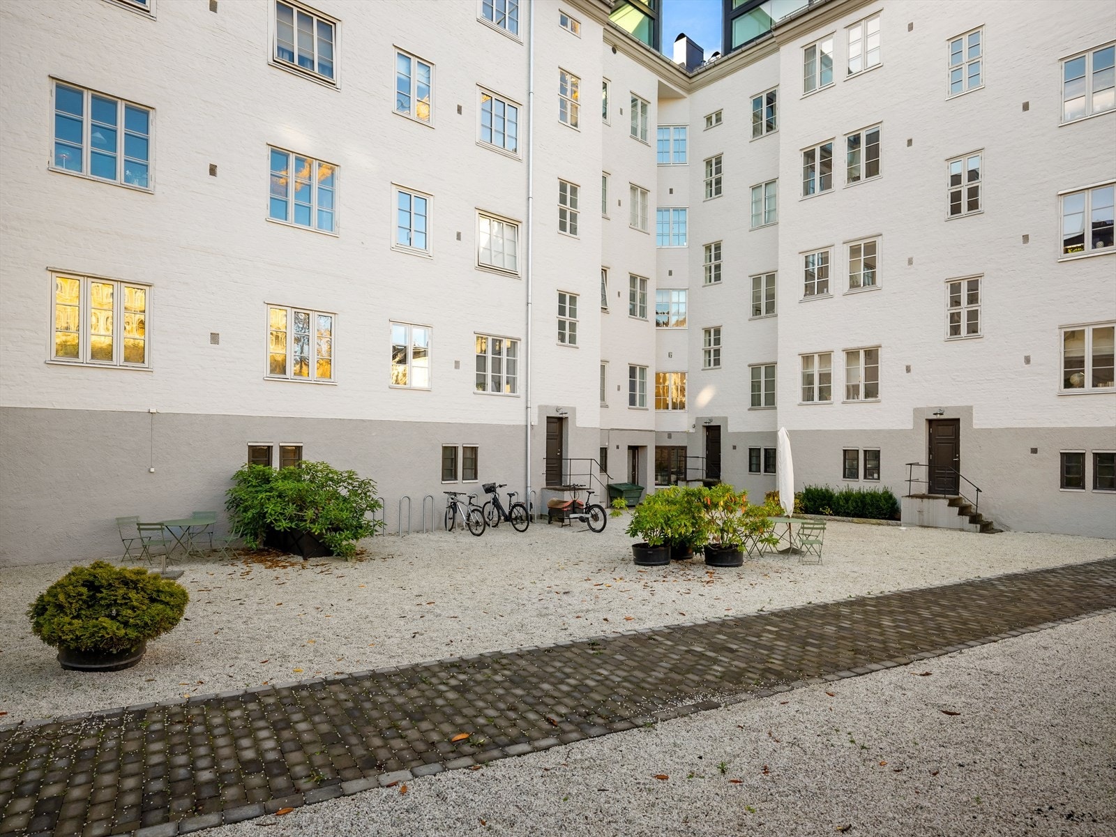 Sjarmerende felles bakgård med flere sittegrupper - perfekt for avslapning og hyggelige sammenkomster. Galleribilde