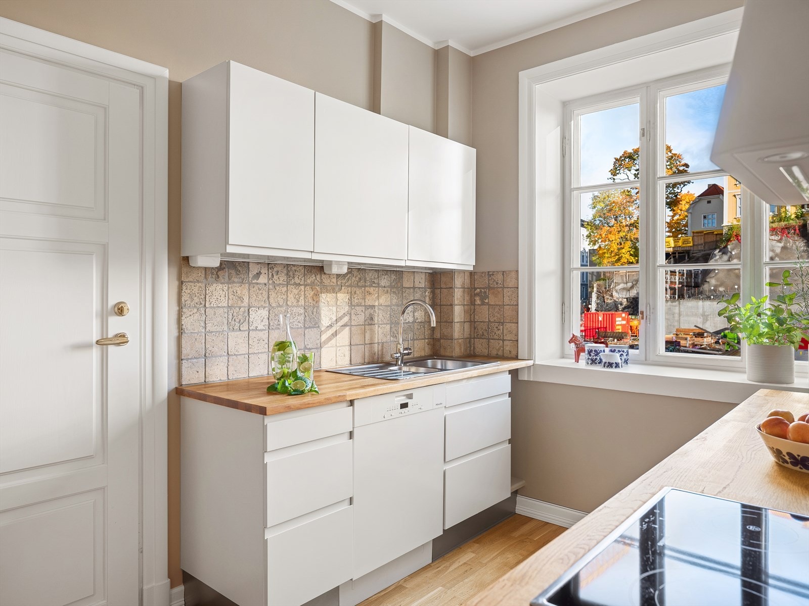 Kjøkken med glassplate over platetopp, heltre benkeplate med planlimt rustfri kum og kullfilterventilator. Galleribilde