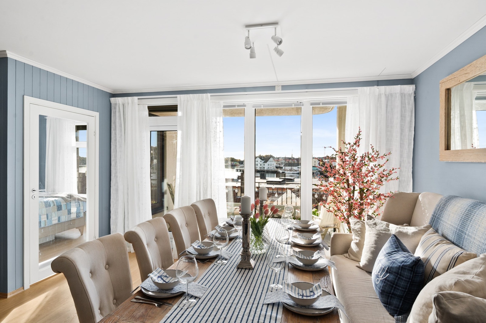 Lys og innbydende stue med spiseplass - store vinduer som slipper inn rikelig med naturlig lys og gir utsyn mot sjøen. Galleribilde