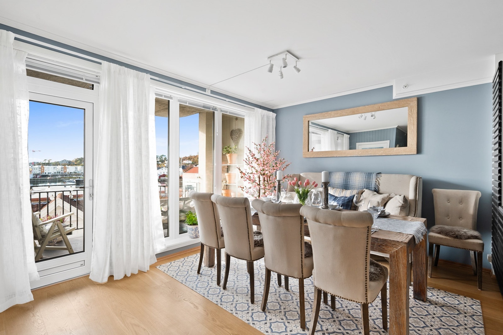 Fra stuen er det utgang til veranda og en vegg med vinduer som rammer inn utsikten og omgivelsene rundt Galleribilde