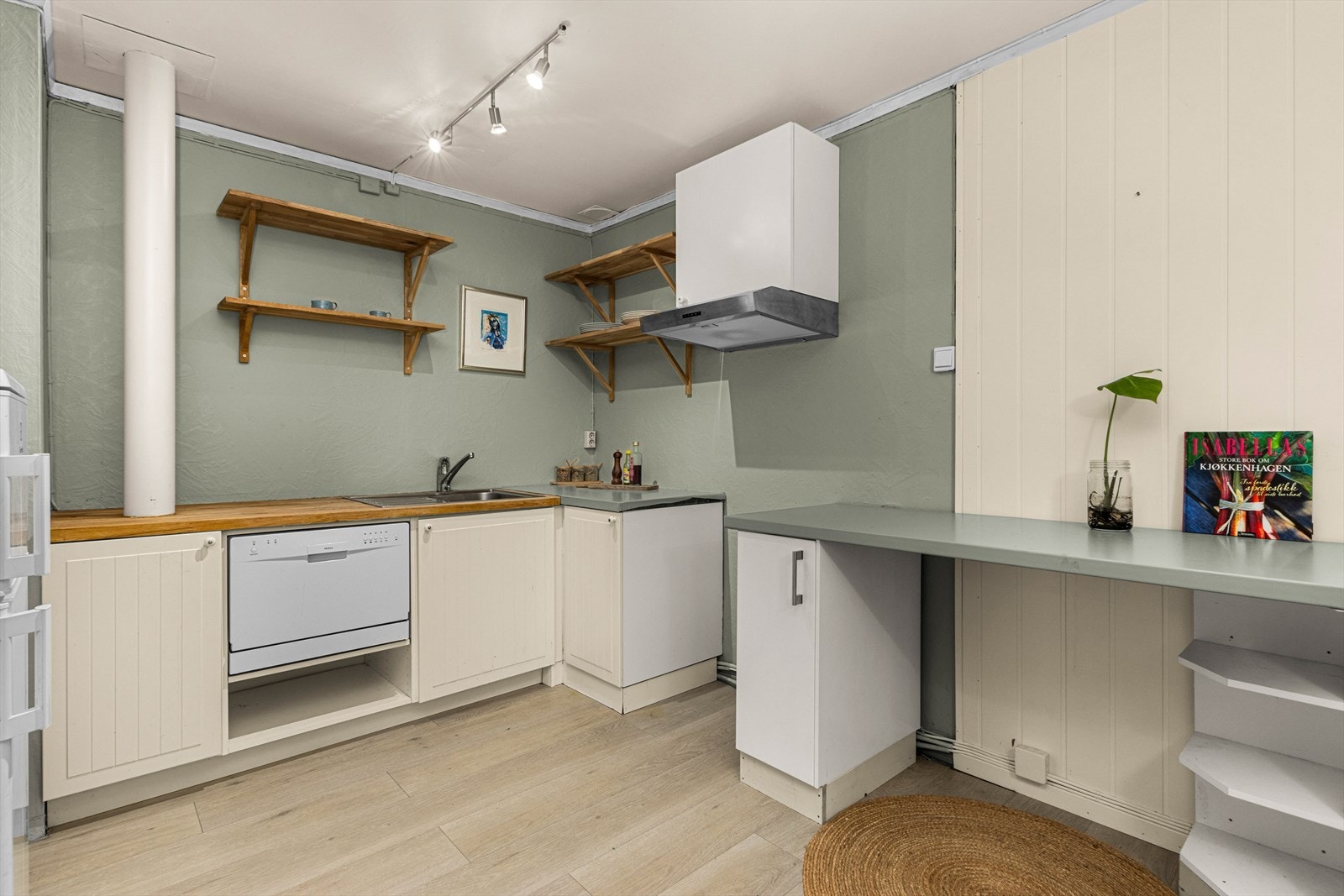 Lyst kjøkken som har fått TG1 fra takstmannen. Innredning med mekanisk avtrekksvifte over stekesonen, bereder og opplegg for oppvaskmaskin. Galleribilde