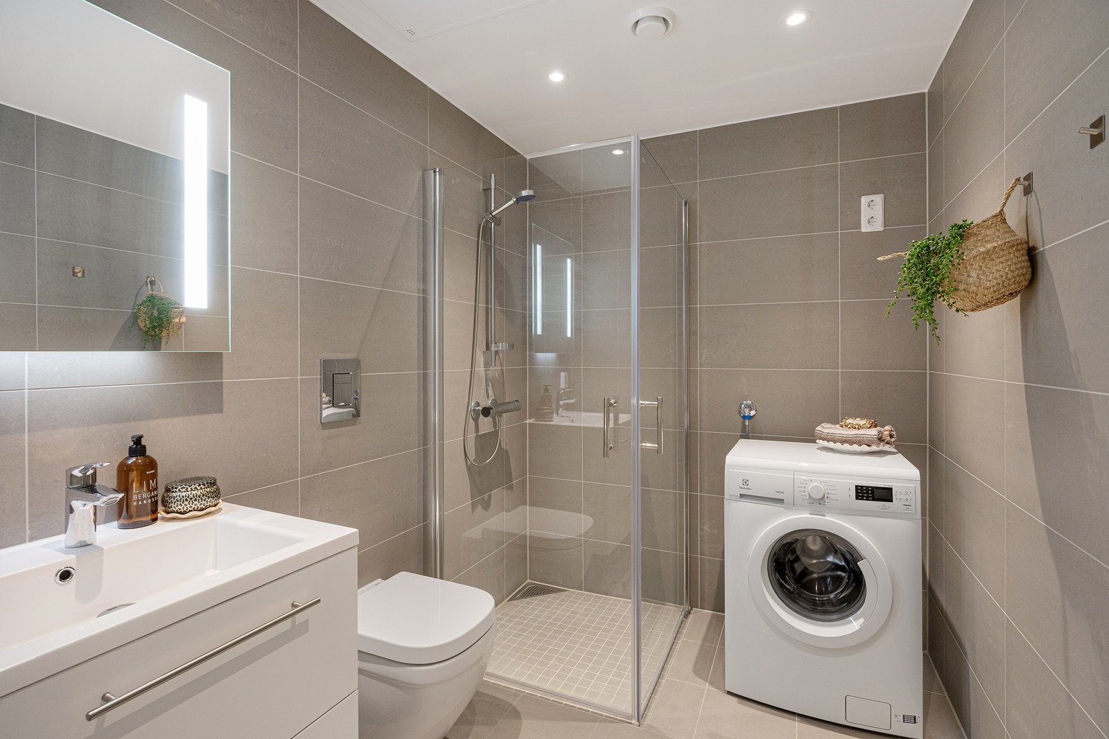 Delikat flislagt baderom med gulvvarme. Det er montert downlights i himlinger. Galleribilde