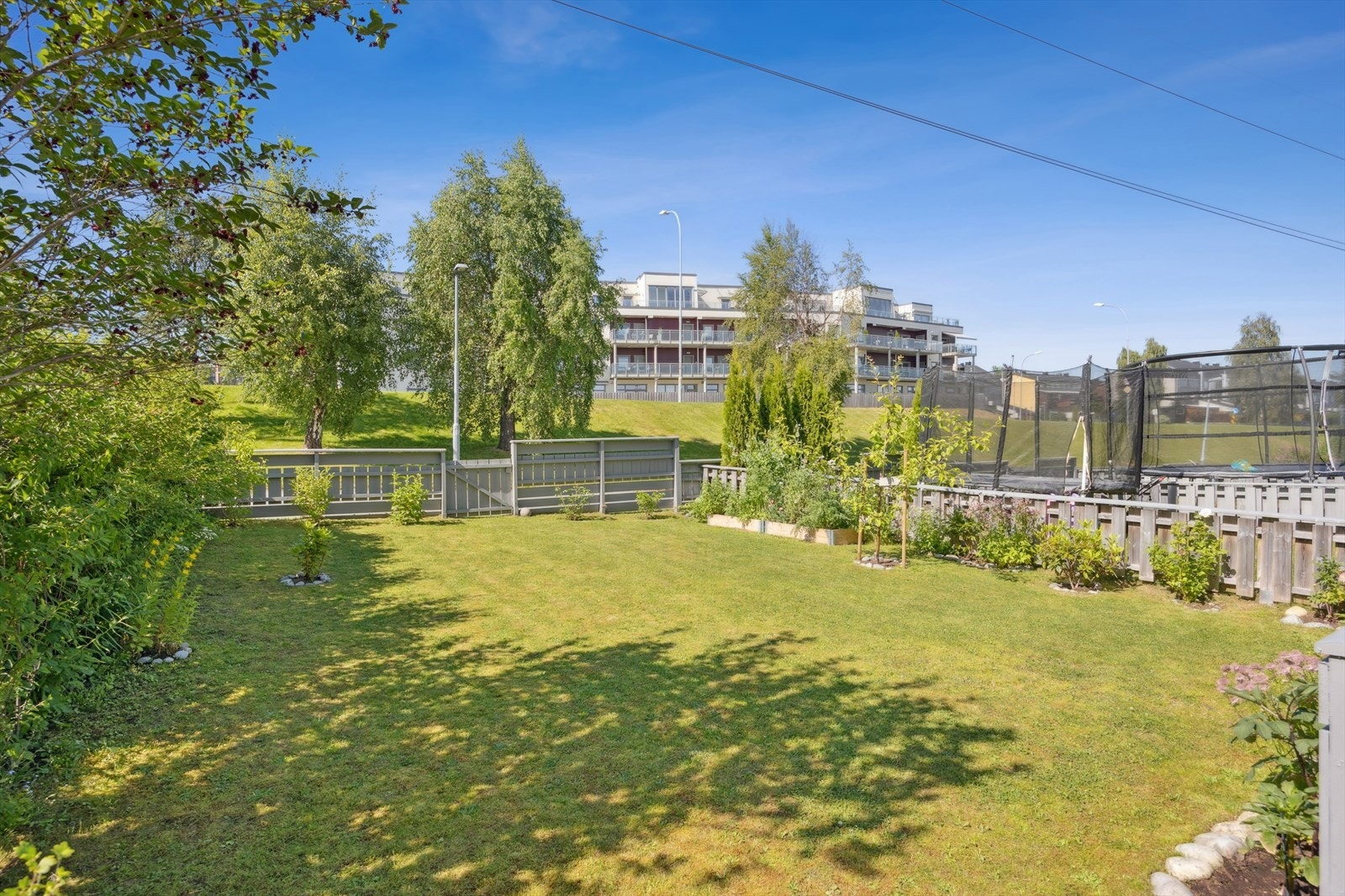 Huset har en romslig og inngjerdet hage, med god plass til trampoline og annet moro. Galleribilde