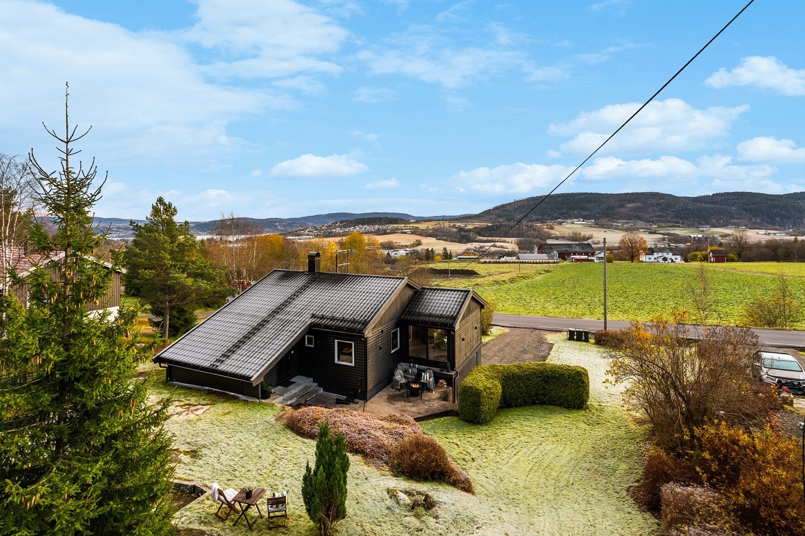 Boligen er omkranset av frodig natur, med utsikt over åpent landskap. Galleribilde