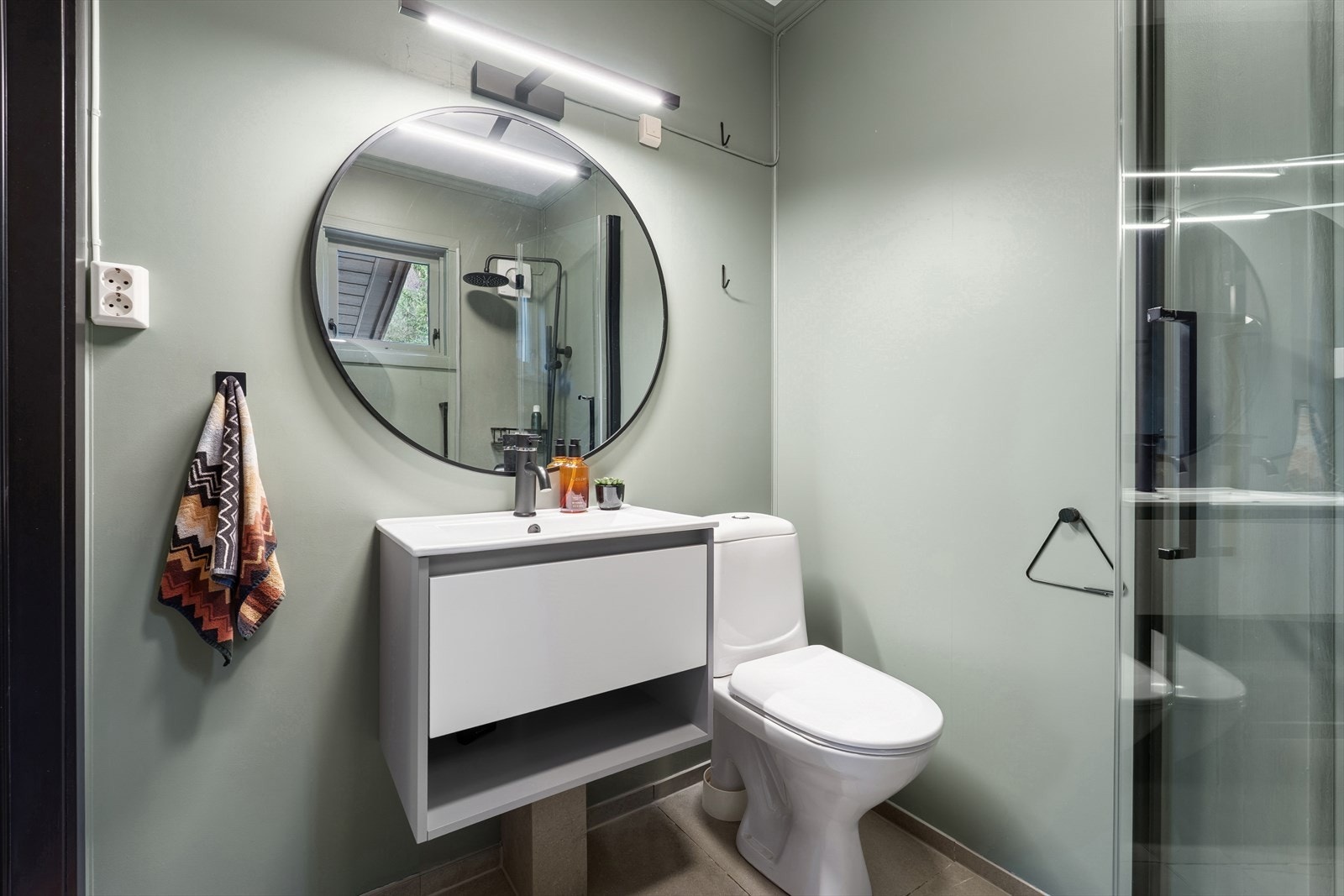 Baderomsinnredning med nedfelt servant og toalett gir et ryddig uttrykk. Elektrisk styrt vifte sørger for god ventilasjon. Galleribilde