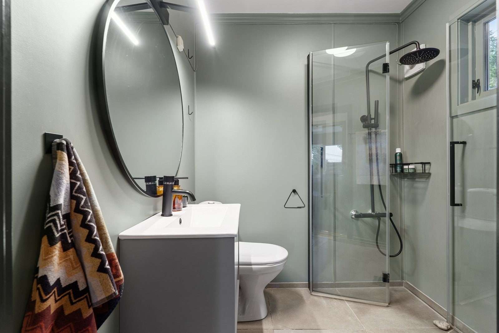 Baderommet er delikat innredet med dusjhjørne med innfellbare glassvegger og vannfalldusj. Galleribilde