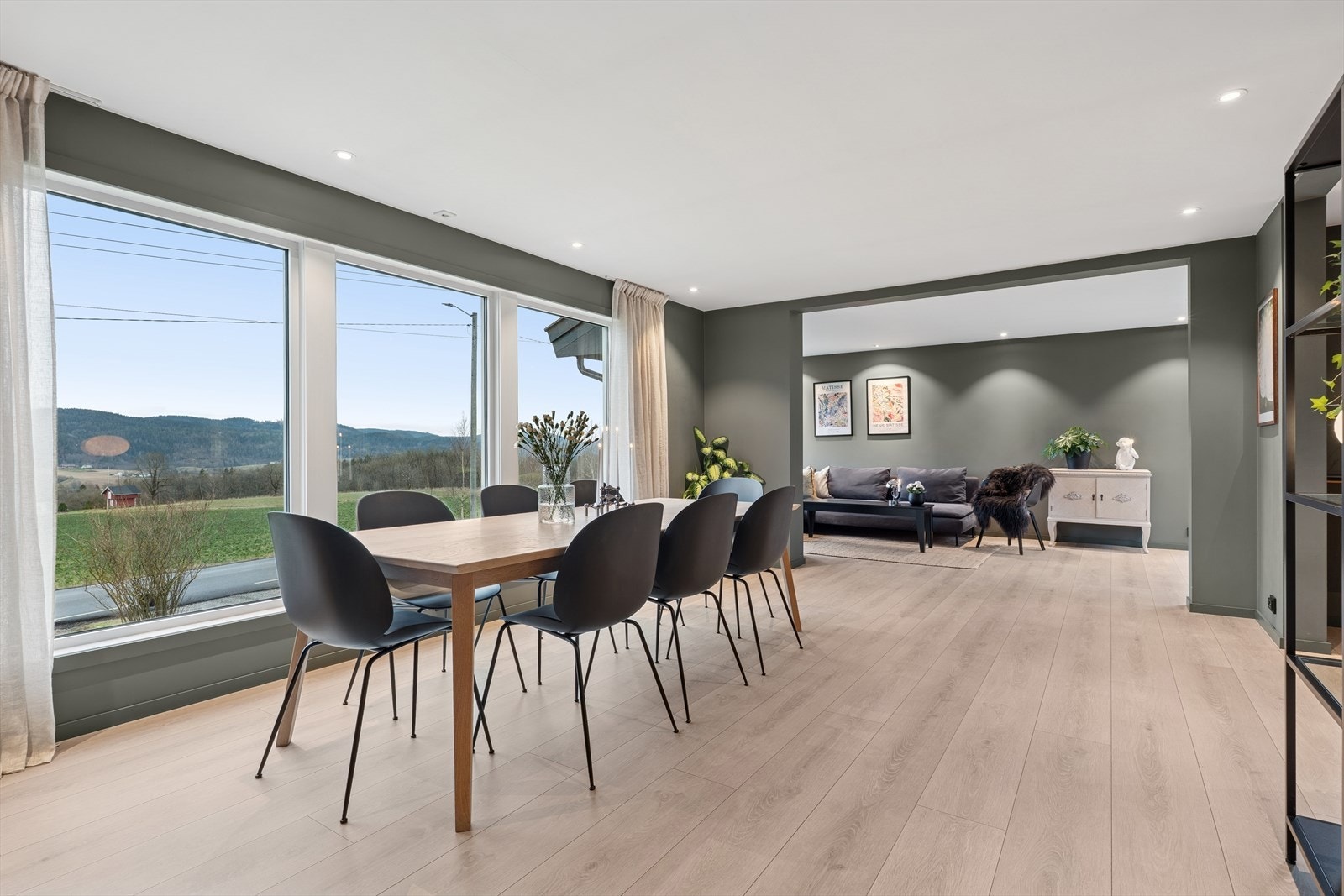 Stuen er romslig og innredet i ulike soner. Store vinduer gir utsikt mot landskapet og mye naturlig lys i stuen. Galleribilde