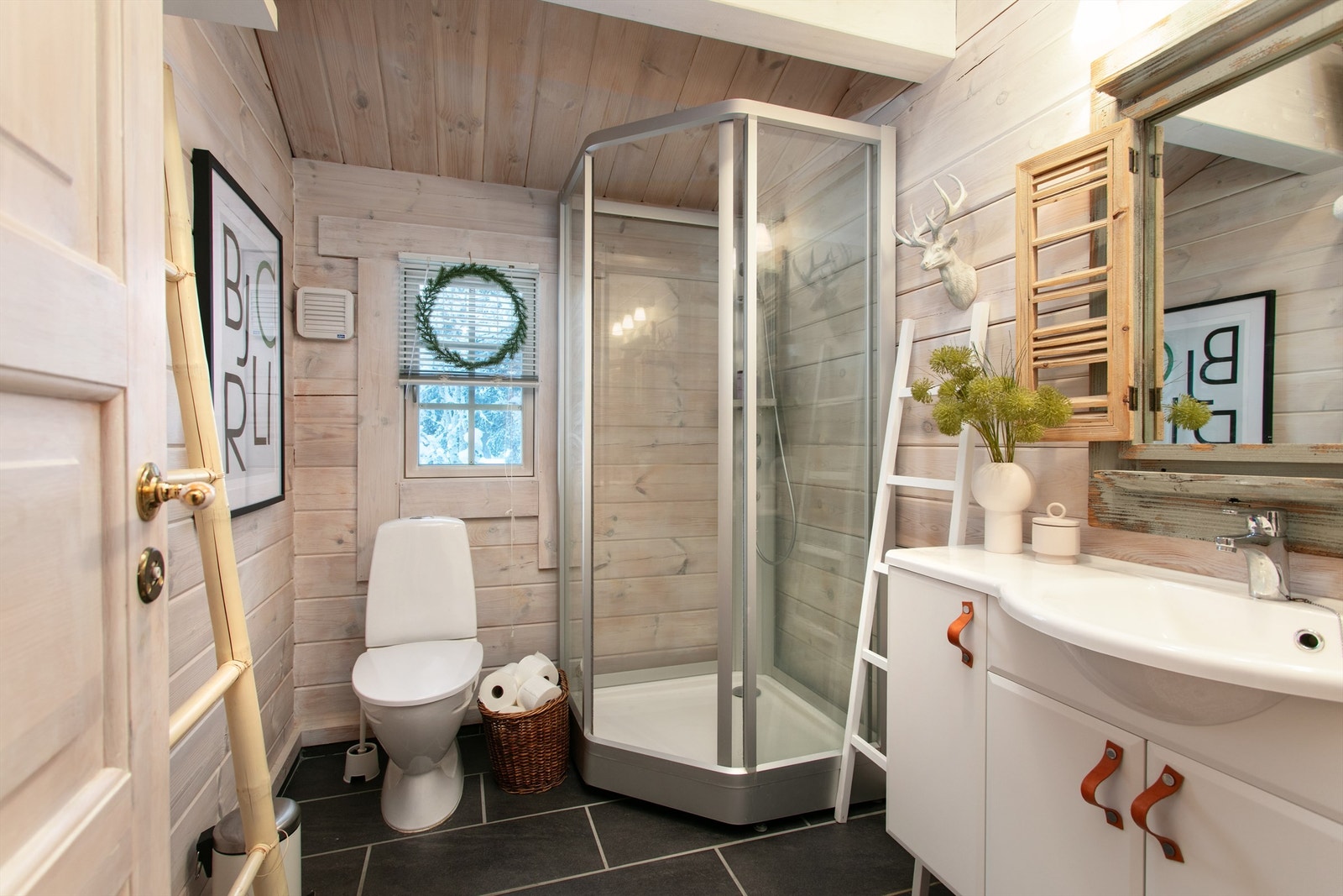 Bad med flislagt gulv, vegger i tømmer og panel i tak. Baderomsinnredning og dusjkabinet Galleribilde