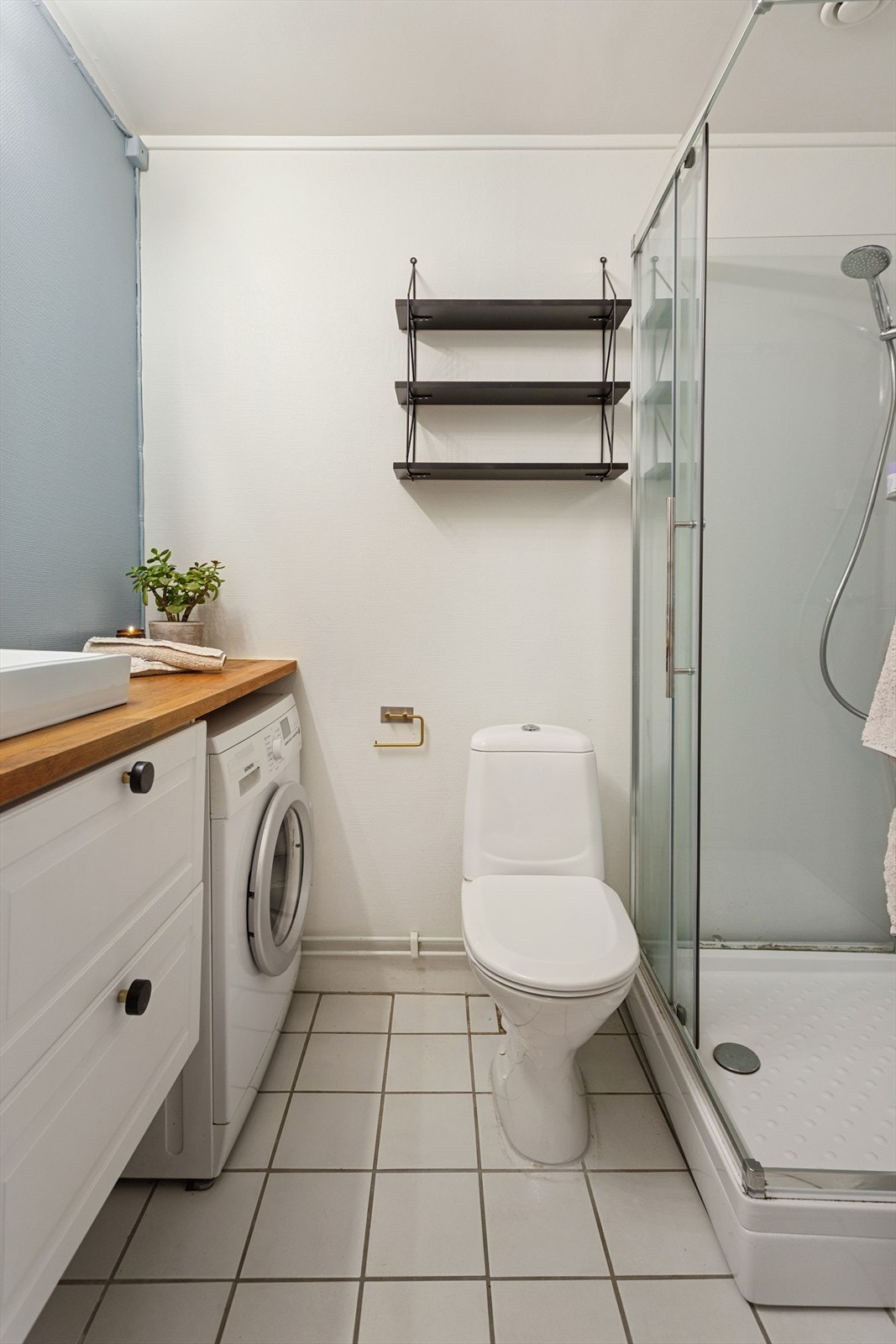 Leiligheten har et tidløst baderom med fliser på gulv. Galleribilde