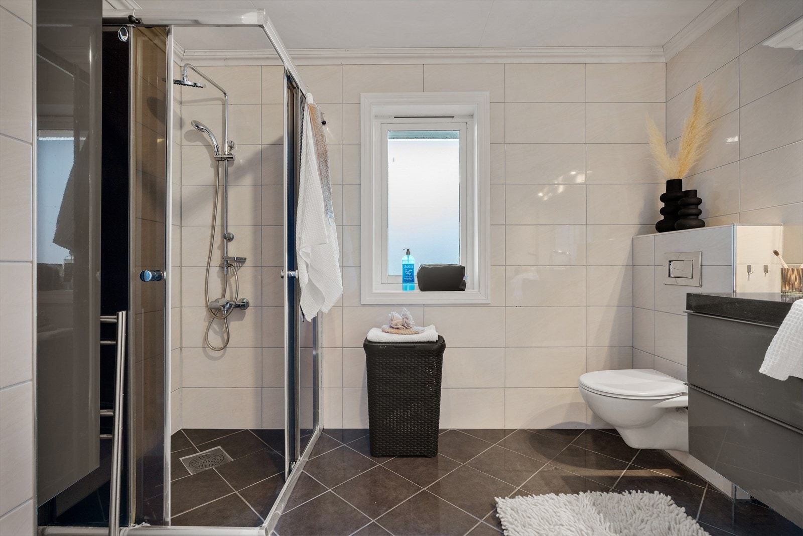 - Badet inneholder dusjhjørne i glass, vegghengt toalett og dobbel servant med møblement - Galleribilde