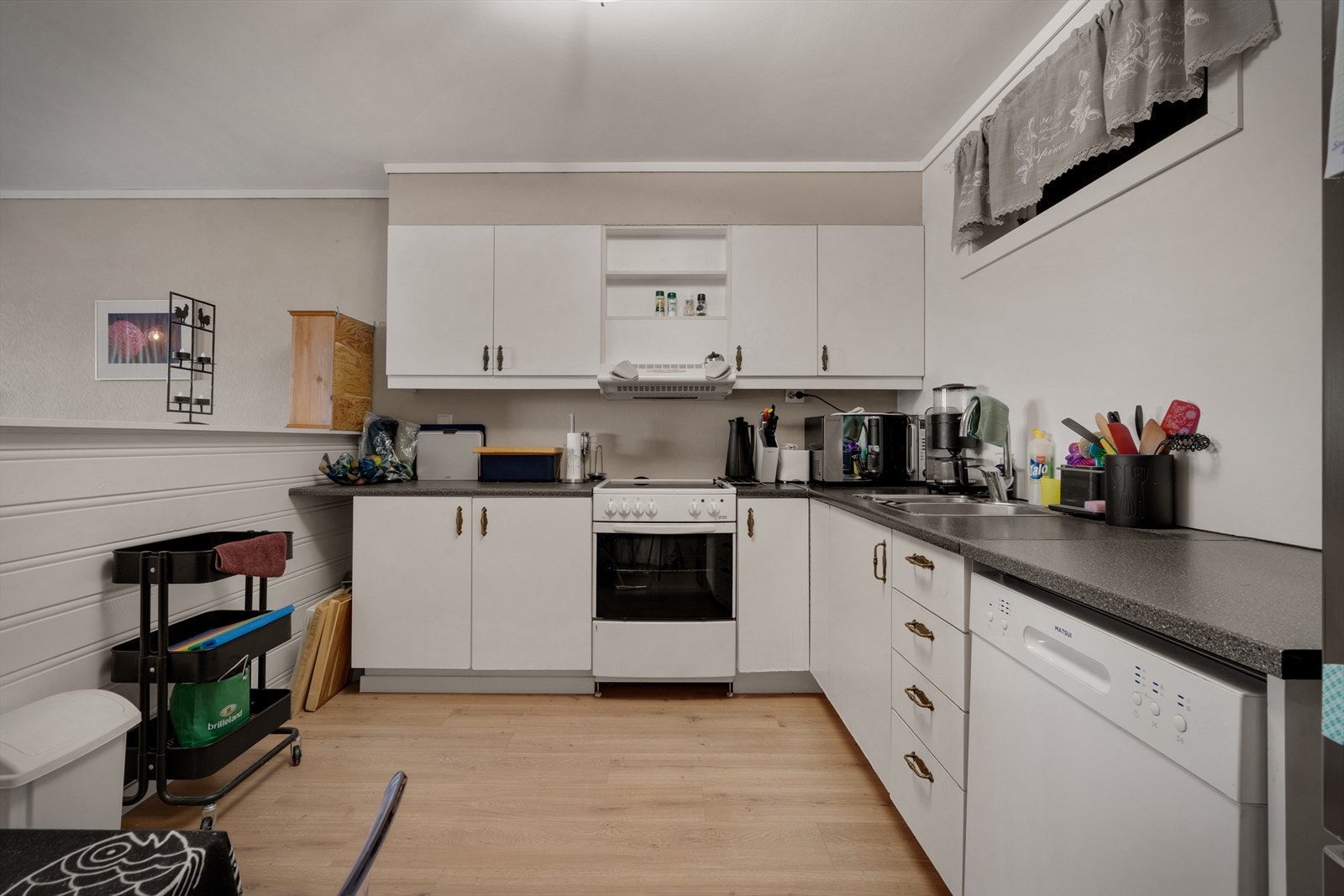 - Kjøkken med slette fronter og laminatbenkeplate. Komfyr, oppvaskmaskin og kjøleskap/frys medfølger handelen helt kostnadsfritt - Galleribilde