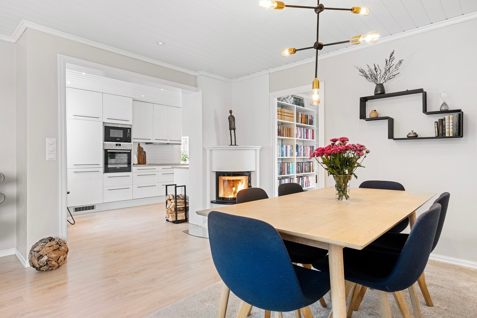 Den store åpningen mellom stue og kjøkken skaper en naturlig og sømløs overgang, og gir en åpen og luftig romfølelse i oppholdsrommet Galleribilde