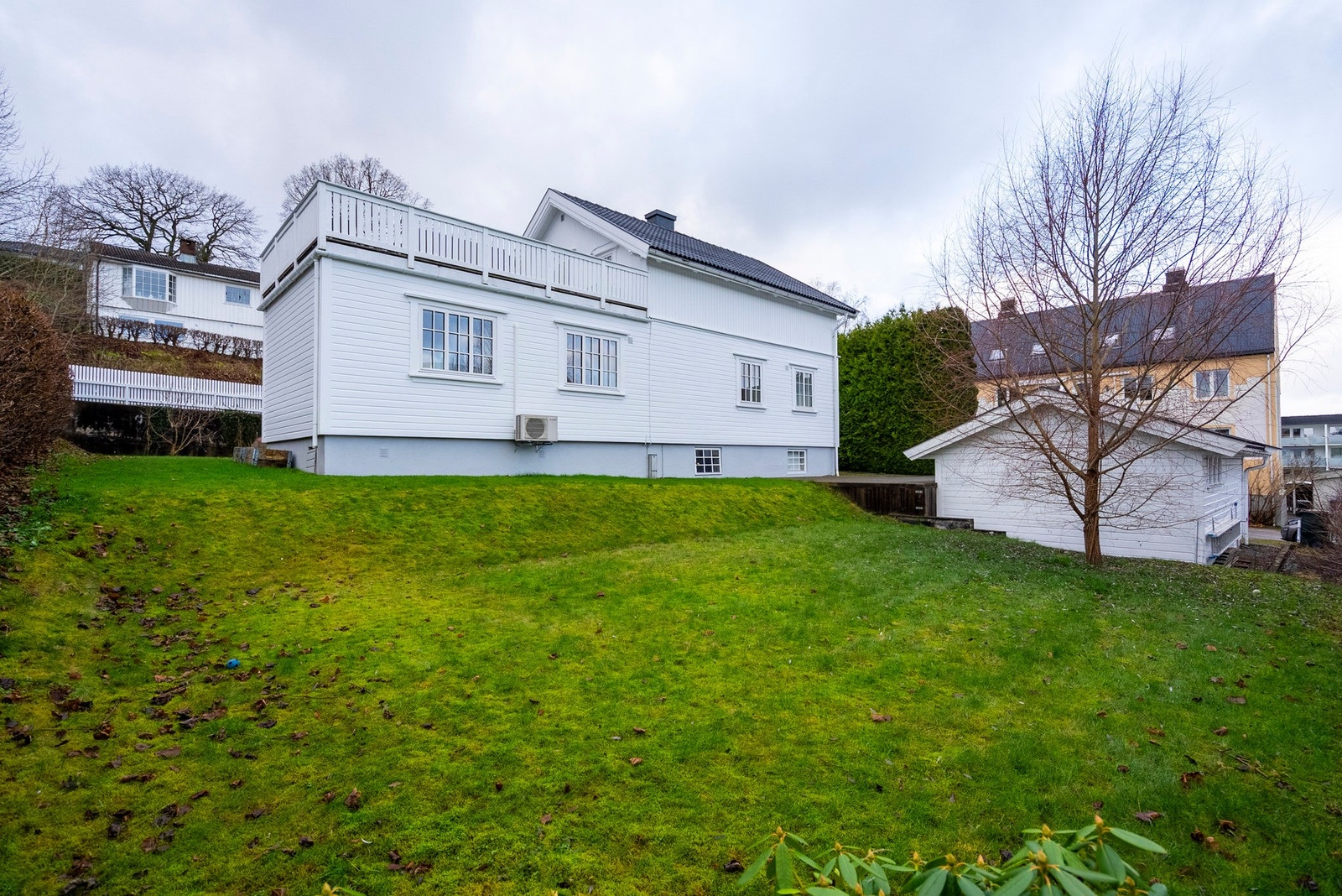 Nedenfor huset har du romslig hageområde som gir muligheten for ballspill, lek og vakker beplantning Galleribilde