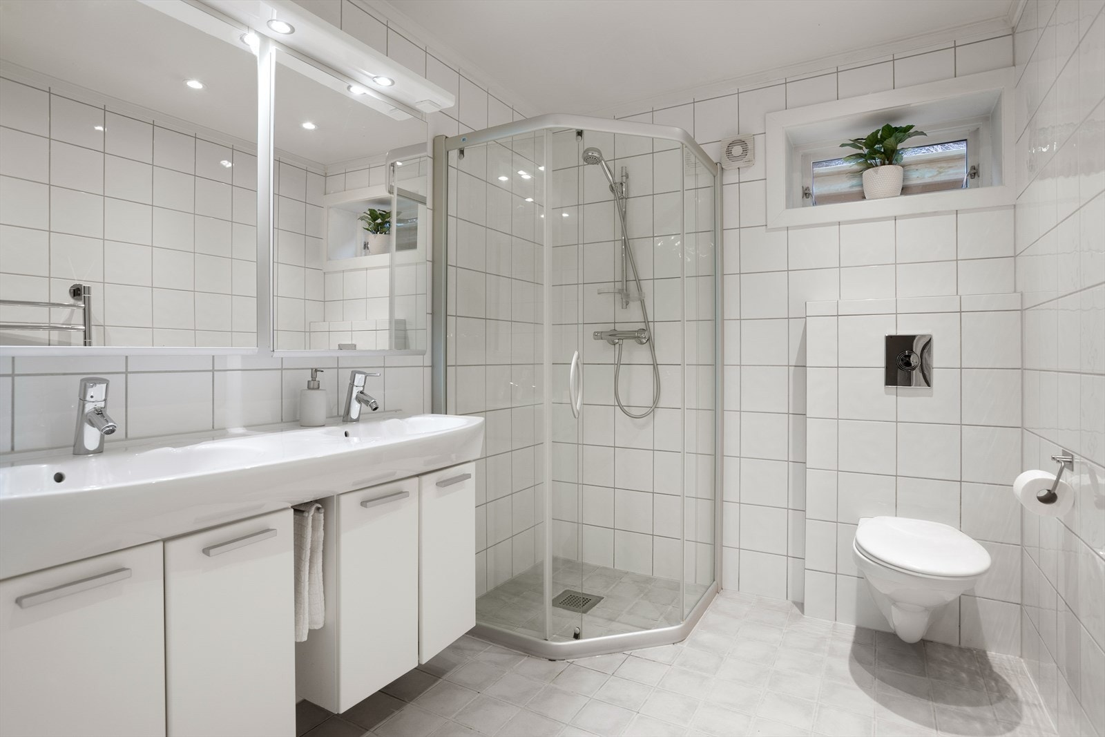 Det andre baderommet ble renovert i 2005 og har flislagte gulv- og veggflater, gulvvarme, dobbel servant, vegghengt toalett og dusjsone. Galleribilde