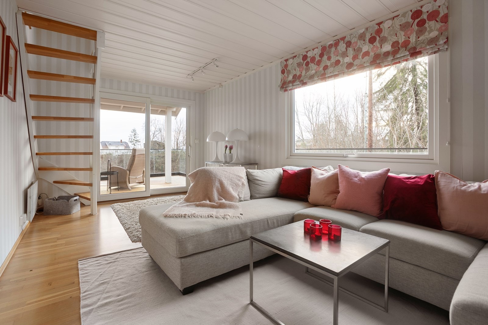 Den lyse og luftige stuen med utsikt har vært et naturlig samlingspunkt i boligen, med en innbydende atmosfære for både hverdag og selskap. Fra stuen er det utgang til verandaen, hvor morgenkaffen kan nytes i rolige omgivelser. Galleribilde