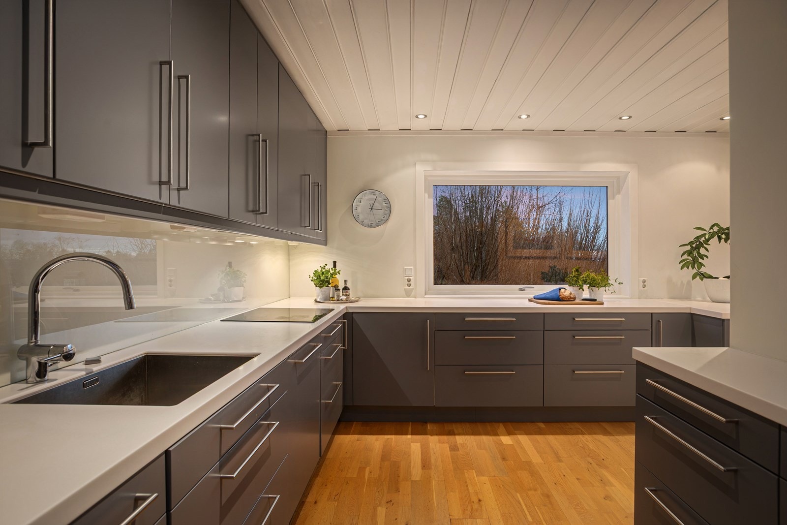 Benkeplaten er i laminat med nedfelt oppvaskkum og ettgreps blandebatteri, og det er glassplate mellom benkeplate og overskap som gir et moderne og lettstelt uttrykk. Galleribilde