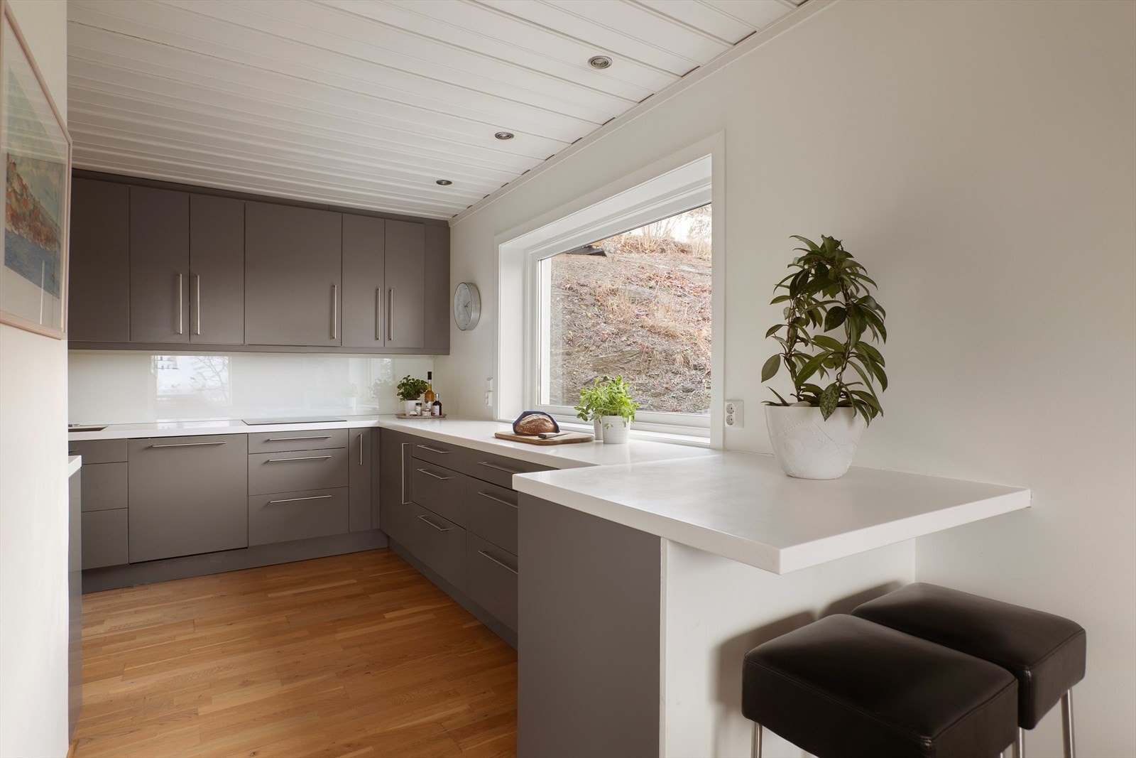 Planløsningen er praktisk utformet med gode arbeidsflater og naturlig forbindelse til spisestuen, noe som gjør kjøkkenet velegnet for både daglig bruk og sosiale anledninger. Galleribilde