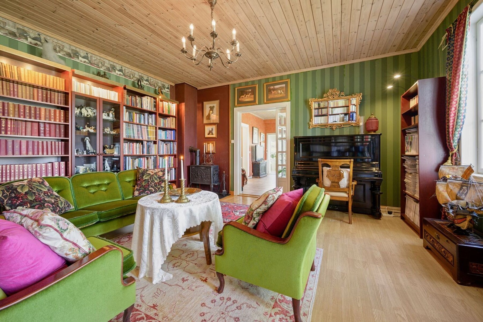 Her er den ene stuen innredet som et hyggelig bibliotek. Galleribilde