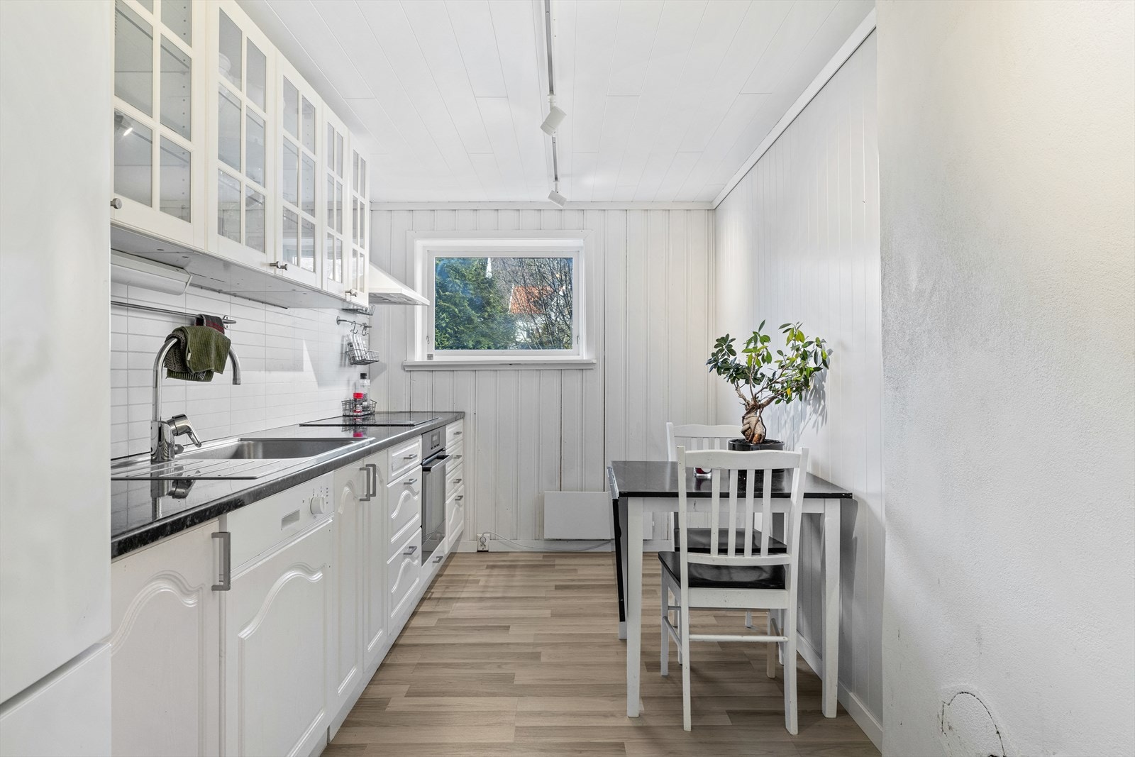 Separat kjøkken fra 2009 med lyse, profilerte fronter og delvis integrerte hvitevarer som medfølger i handelen. Galleribilde