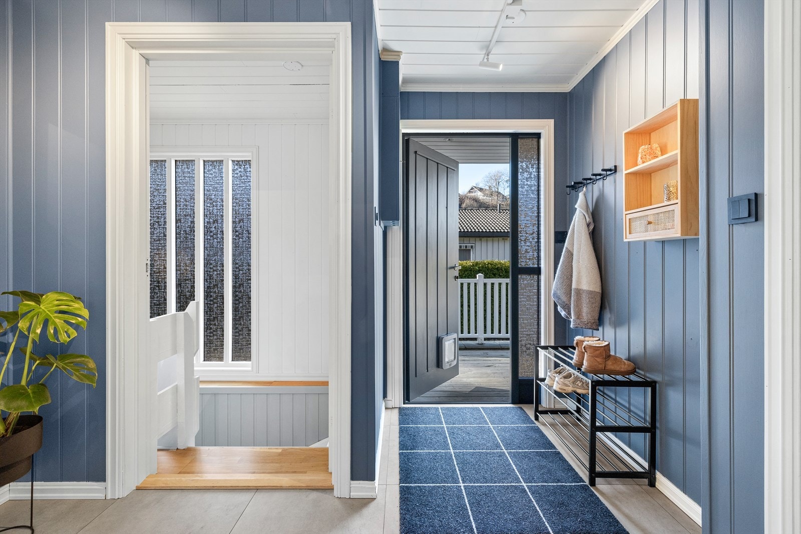 Hoveddelen av boligen har inngang i første etasje. Entréen er innbydende med store, lyse fliser på gulvet og malte panelvegger/tak. Galleribilde