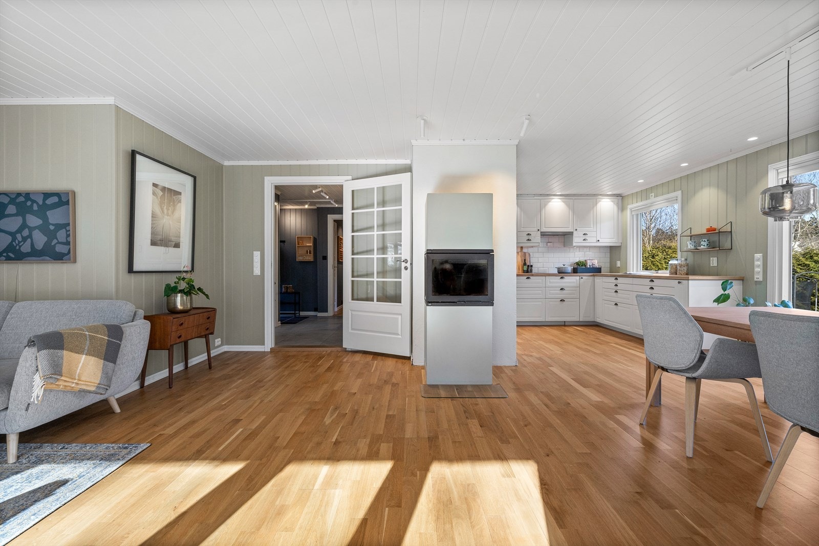 Midt i rommet er det montert en stemningsfull og moderne peisovn for ekstra varme og hygge. Det er også installert varmepumpe i 2022. Galleribilde