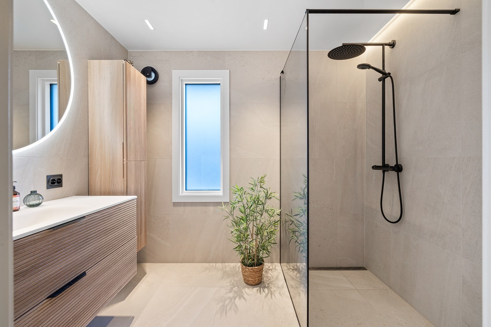 Badet i første etasje ble smakfullt opppusset i 2024. Rommet har store, lyse fliser på gulv og vegger, samt gulvvarme, downlights og avtrekksvifte. Galleribilde