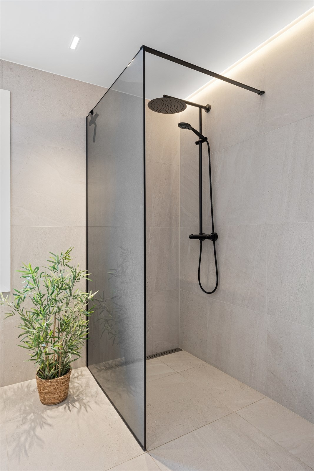 Badet har også et romslig dusjhjørne med regnfallsdusj, hånddusj og glassvegg. Galleribilde