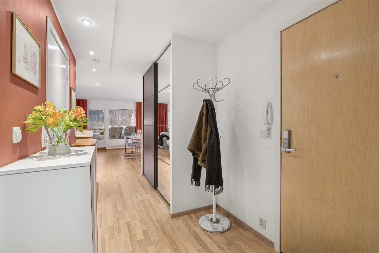 Velkommen inn i en lys og romslig entré med skyvedørsgarderobe Galleribilde