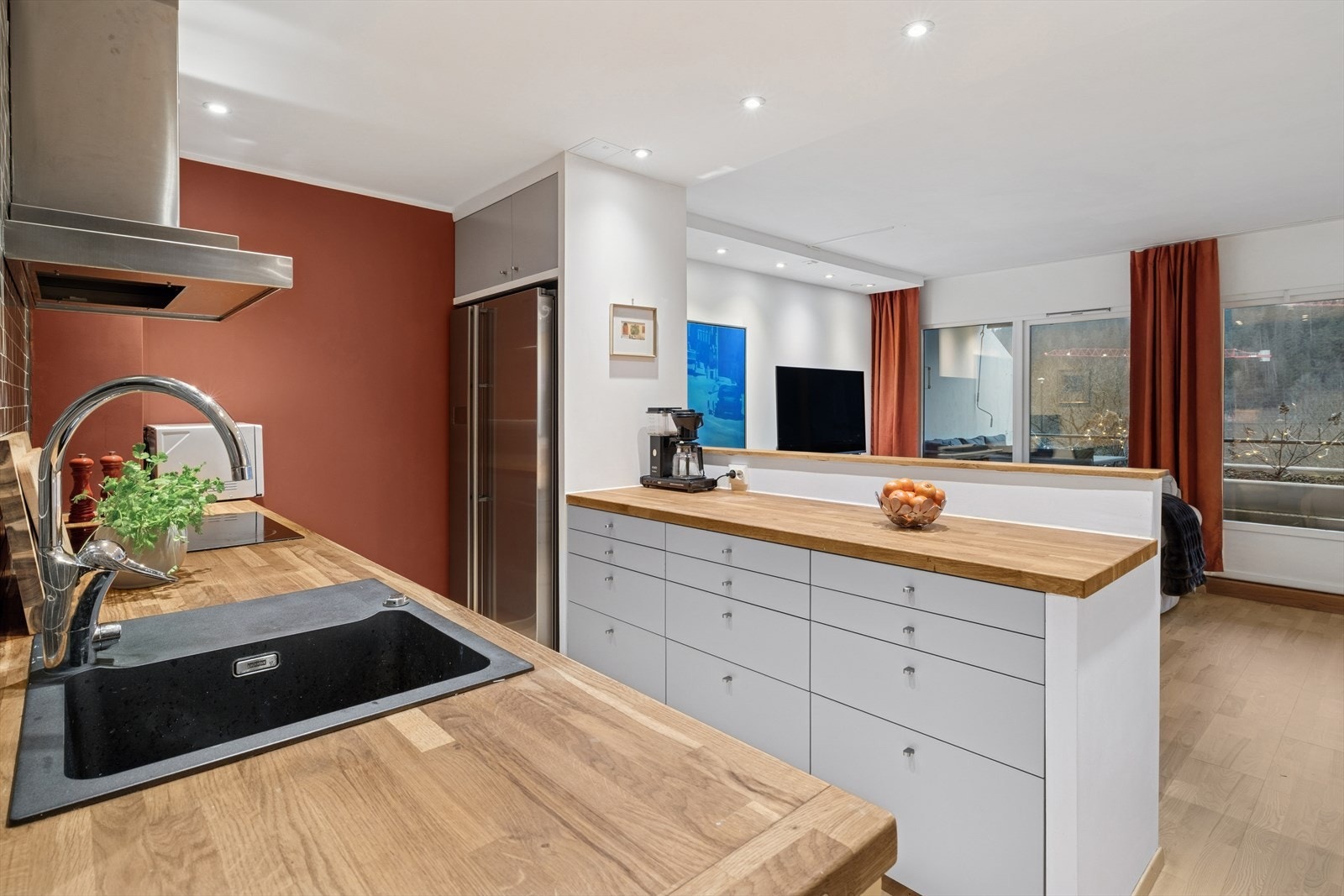 Lyst og pent kjøkken med glatte fronter og benkeplate i heltre. Galleribilde