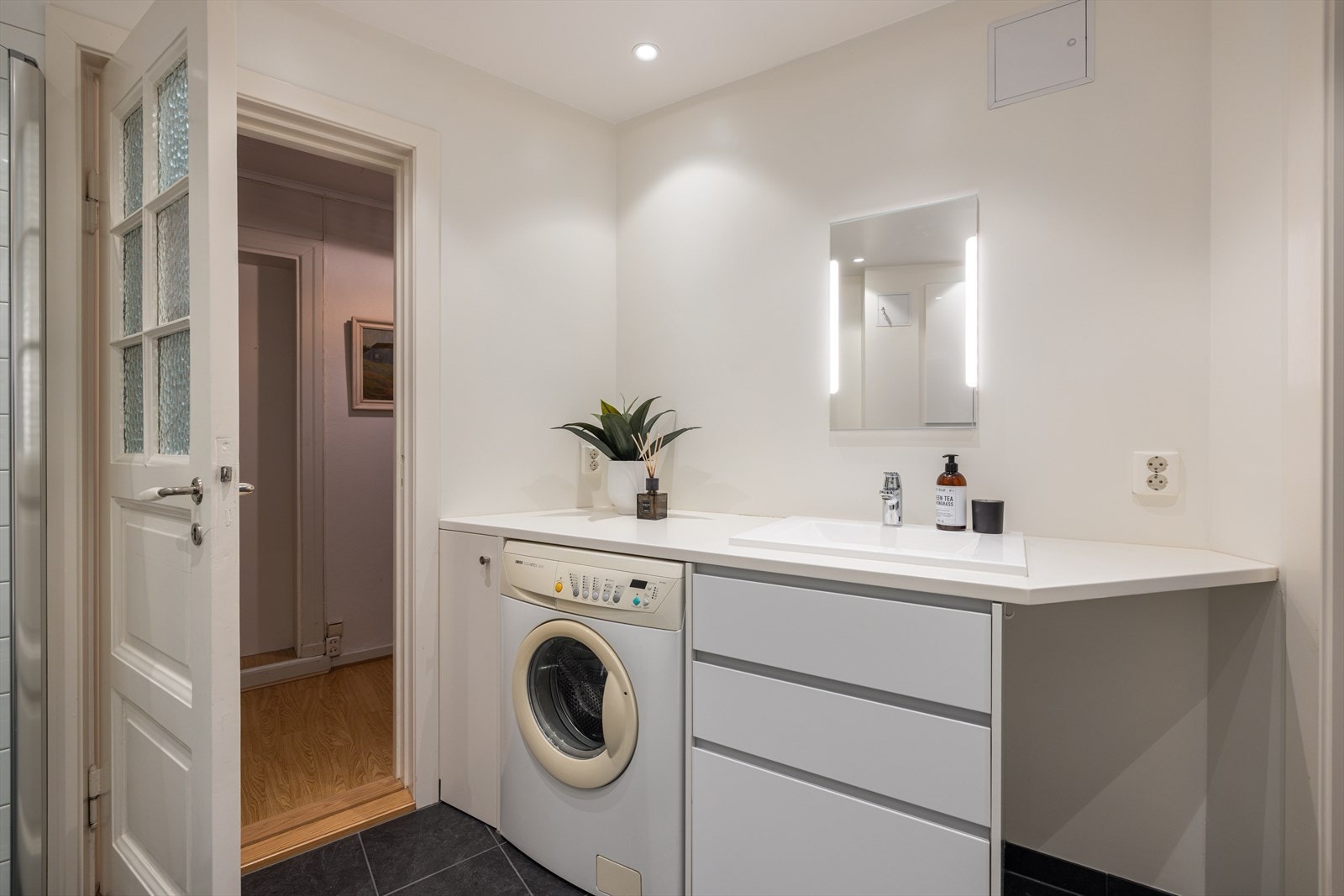 Badet er utstyrt med vegghengt wc, servant med skuffer under, dusj i
hjørne med innad slående dører samt opplegg for vaskemaskin. Galleribilde