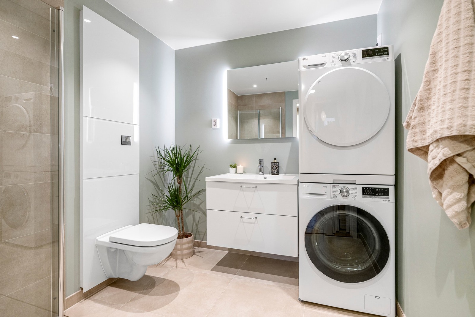 Pent bad med fliser på gulv og i dusjsone. Baderomsinnredning er levert av Sigdal. Speil over baderomsinnredning med integrert belysning. Galleribilde