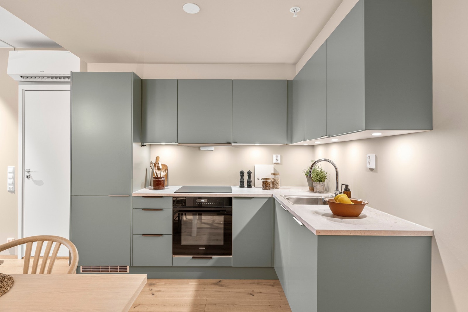 Benkeplate er i laminat og det er belysning under overskap. Galleribilde