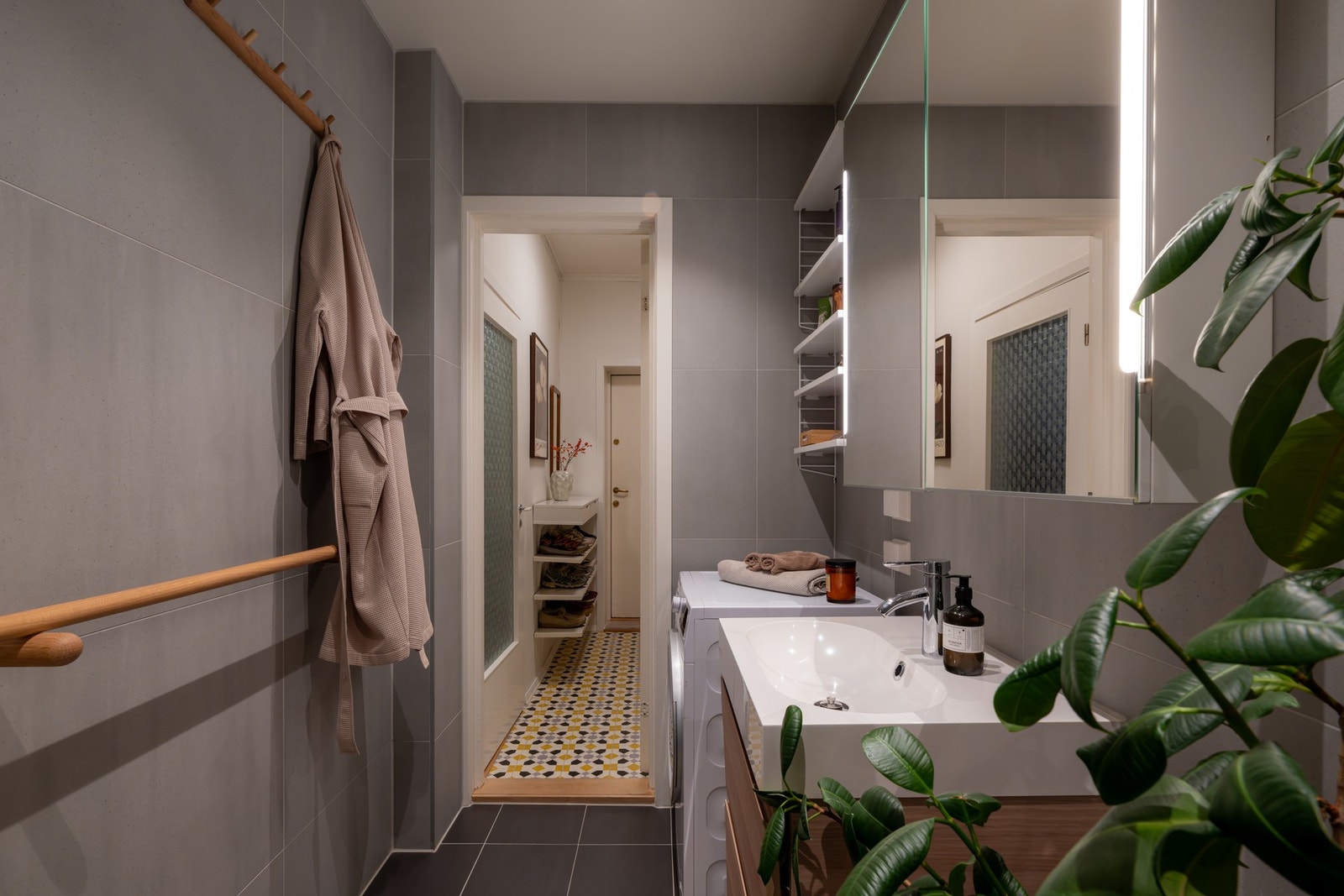 Videre er badet utstyrt med regnfalldusj med innfellbar dusjdør, samt praktisk skap og smart hylleløsning. Det er opplegg for vaskemaskin. Galleribilde